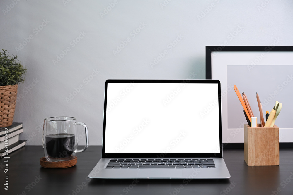 Wall mural front view computer laptop with empty display, pencilholder and picture frame on wooden table.
