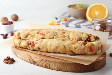Unbaked Stollen with candied fruits and raisins on white wooden table, closeup