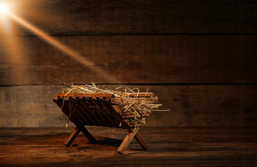 Fototapeta Manger with hay on wooden background. Concept of Christmas story obraz