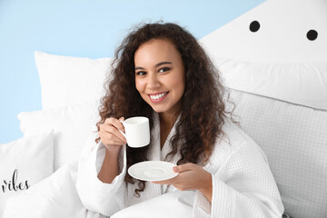 Morning of young woman drinking coffee in bed