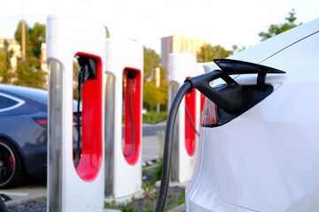 Tesla light electric cars replenish battery at charging station, alternative energy development...
