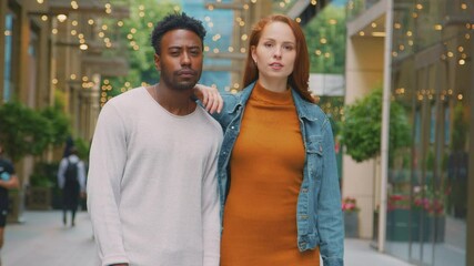 Portrait of young couple of vloggers or social influencers travelling through city street for social media - shot in slow motion