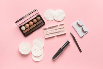 Obraz na płótnie Canvas Eyeshadows, mascara, false eyelashes, tweezers and cotton pads on pink background