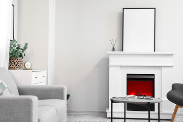 Interior of light living room with fireplace and blank frame