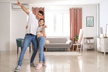 Fototapeta na wymiar Man and his little daughter dancing at home