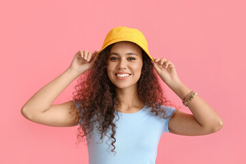 Naklejka premium Beautiful African-American woman in stylish hat on color background