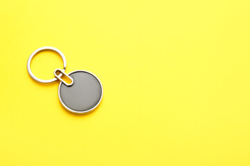 Stylish round keychain on yellow background