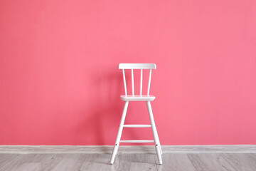 Modern chair near pink wall
