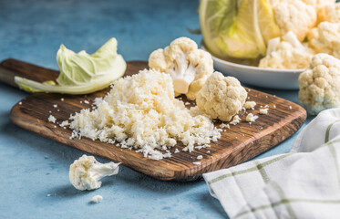 Cauliflower rice in a bowl on light stone background with free text space.