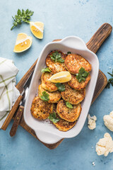 Vegan cauliflower vegetable fritters on the kitchen table. Fried vegetarian cutlets or pancakes. The concept of fast food.
