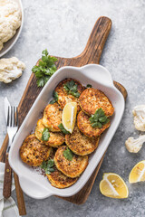 Vegan cauliflower vegetable fritters on the kitchen table. Fried vegetarian cutlets or pancakes. The concept of fast food.