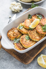 Vegan cauliflower vegetable fritters on the kitchen table. Fried vegetarian cutlets or pancakes. The concept of fast food.