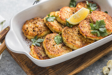 Vegan cauliflower vegetable fritters on the kitchen table. Fried vegetarian cutlets or pancakes. The concept of fast food.