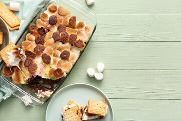 Baking dish with delicious S'mores dip and crackers on color wooden background - obrazy, fototapety, plakaty