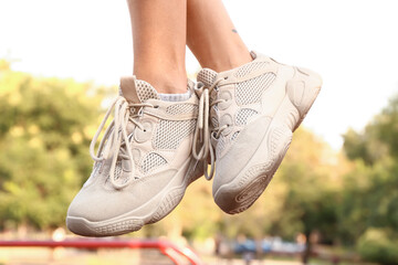 Woman in white sneakers on sport ground, closeup