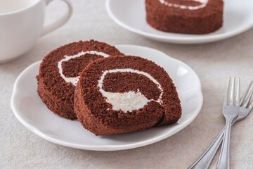 Chocolate roll cake on white plate