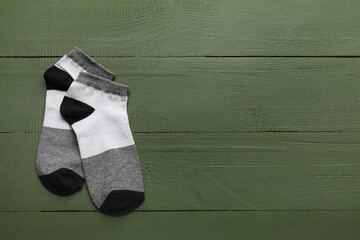 Pair of socks on color wooden background