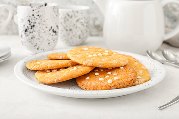Tasty cookies with chocolate chips in plate on light background, closeup