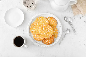 Tasty cookies with chocolate chips in plate and cup of coffee on light background