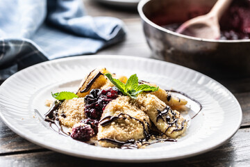 Freshly made pierogi served with forest berries sauce and mint leaves on top