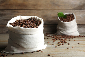 Bag of roasted coffee beans on wooden table. Space for text