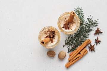Fototapeta na wymiar Eggnog with cinnamon and nutmeg for winter holidays. Christmas traditional eggnog in glasses on white background 