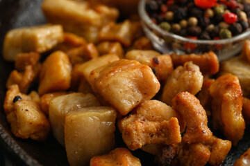 Tasty cracklings in frying pan, closeup