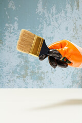 Man holding wooden painter brush.