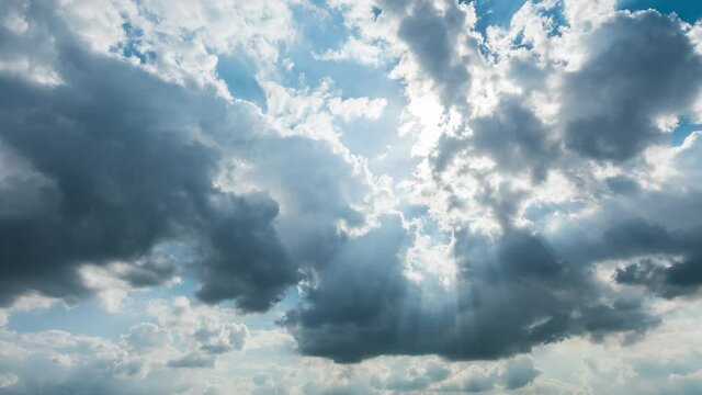 Fast rolling clouds in the blue sky. Clouds and sun rays time lapse.