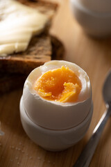 Still life breakfast. Boiled egg with salt, homemade bread with butter. Front view.