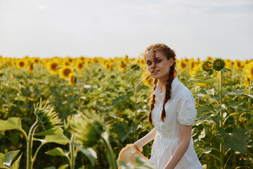 woman with pigtails walks through a field of sunflowers countryside