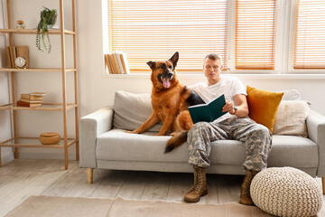 Soldier of USA army with military working dog reading book at home