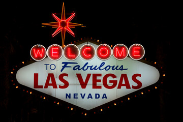 The "Welcome to fabulous Las Vegas Nevada" sign is shown at night. The 25-foot-tall sign was designed and installed in 1959 and marks what is considered to be the southern end of the Las Vegas Strip.