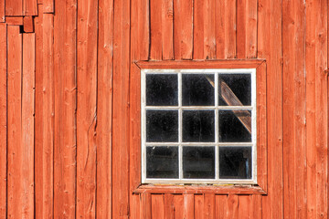 Fototapeta na wymiar Red weathered barn with a window