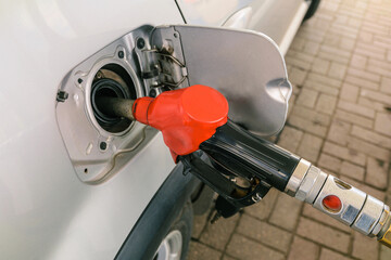 Pumping petrol at gas station into vehicle.