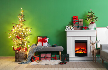 Interior of stylish living room with grey ottoman, fireplace and Christmas trees