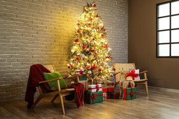 Beautiful Christmas tree with glowing lights, gifts and chairs near brick wall