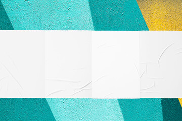 Closeup of geometrical teal mint yellow painted urban wall texture with four wrinkled glued poster templates. Modern mockup for design presentation. Creative geometric urban city background. 