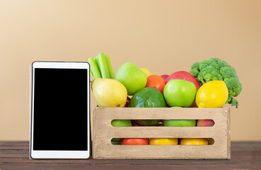 Online concept of food delivery - fruit and vegetables and tablet screen