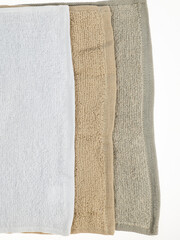 three napkins towels of different colors of the same size on a white background