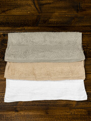 three napkins towels of different colors of the same size on a white background