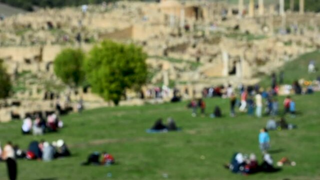 Blurred group of families enjoying spring day near Roman ruins in Djemila, Setif, Algeria