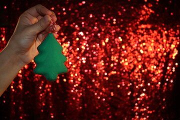 beautiful green Christmas tree is lying on your hand on a shiny background