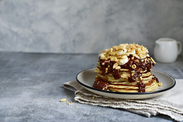 Banana pancakes with chocolate sauce and nuts.