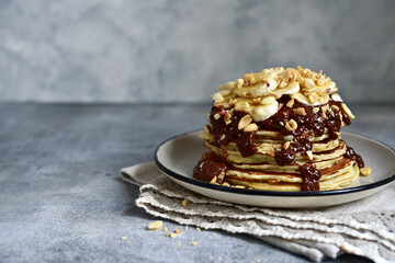 Banana pancakes with chocolate sauce and nuts.