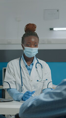 Woman working as medic at healthcare clinic doing consultation for old patient with disability....