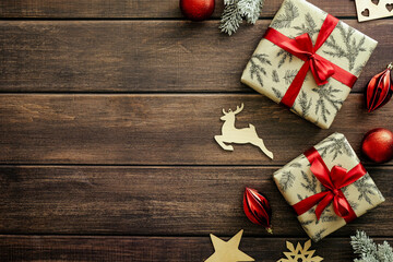 Christmas composition. Vintage Christmas gifts, wooden decorations, red baubles on wood planks background. Flat lay, top view. Christmas card template.