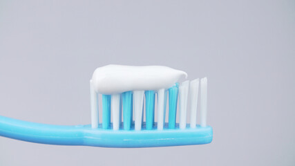 Photo of squeezed toothpaste on toothbrush on white background