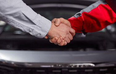 Customer and car mechanic shaking hands