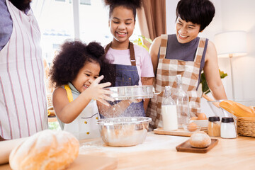 African American family help prepare the flour for making cookies. Happy African American family